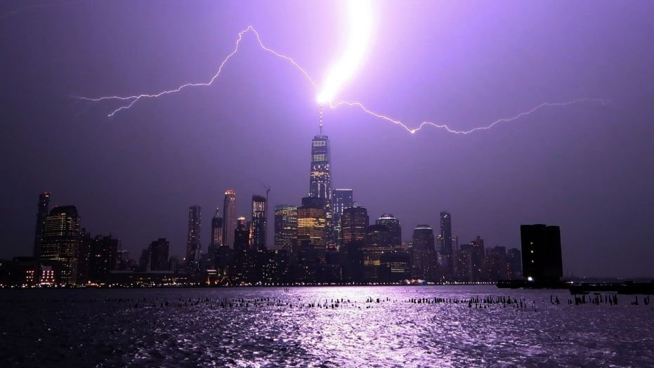 HOBOKEN, NJ - AUGUST 22: Lightning lights up the sky over lower Manhattan as a bolt strikes One World Trade Center in New York City on August 22, 2017 as seen from Hoboken, New Jersey. (Photo by Gary Hershorn/Getty Images)