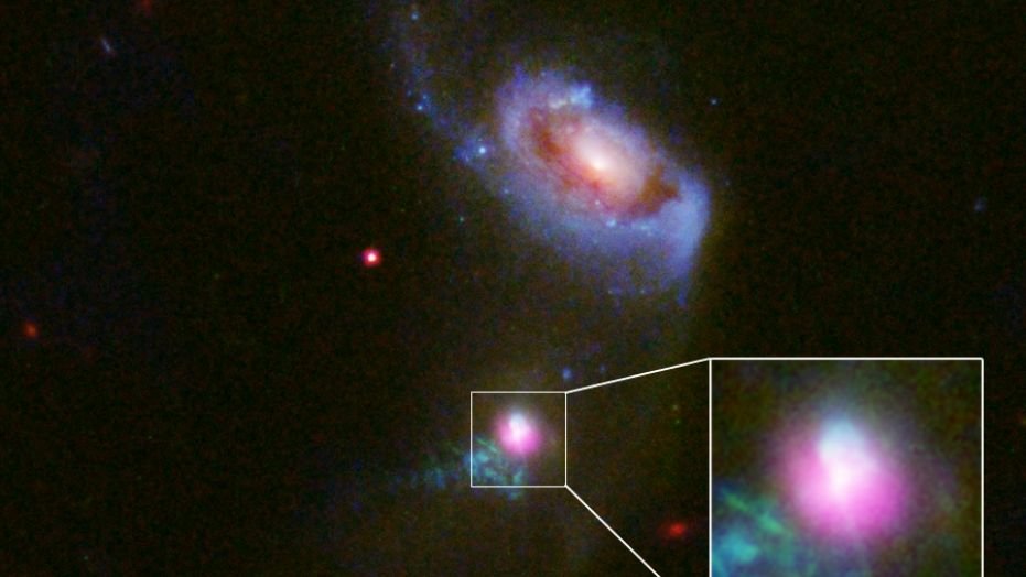 Researchers observed the supermassive black hole at the center of the galaxy SDSS J1354+1327 with the Chandra X-ray Telescope (pink) and Hubble Space Telescope, noticing evidence of two &quot;burps&quot; of high-energy particles emanating from the black hole. One (below the black hole) has spread further, suggesting it burst out 100,000 years before the other (above the black hole).