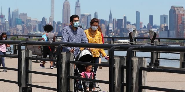 A general view of people wearing masks walking on the promenade as New Jersey continues with its Phase 1 of reopening the state during the Coronavirus (COVID-19) pandemic on May 16, 2020, at Liberty State Park in Jersey City, NJ.