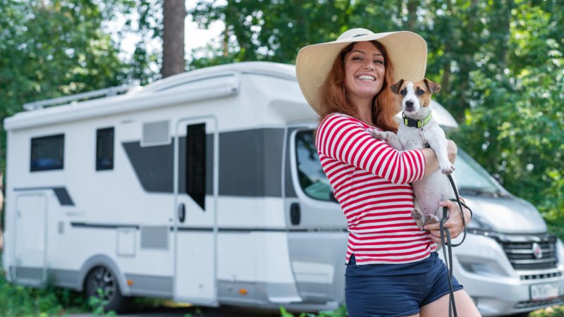 Woman Holding Dog in Front of an RV 800x450 - Pet Travel Hacks To Save You Money